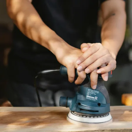 Mann arbeitet mit Schleifmaschine